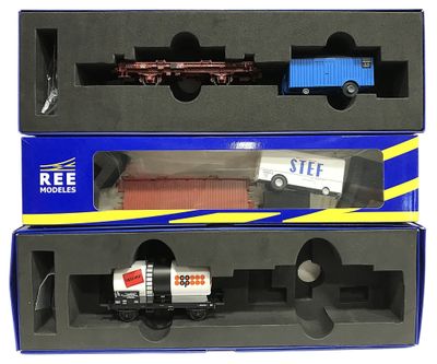 deux boîtes contenant des petits trains miniatures, posées sur une surface blanche