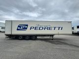 un semi-remorque blanc garé sur un parking à côté d'autres semi-remorques