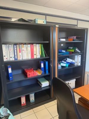 a desk with a chair and bookshelf in a room