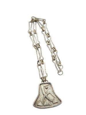 a close up of a necklace with a bell on a chain