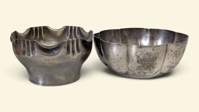 two metal bowls sitting next to each other on a white surface
