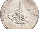 Gros plan sur une pièce de monnaie en argent portant une inscription en arabe