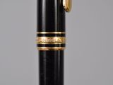 a close up of a fountain pen with a gold trim
