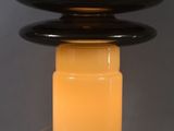 a close up of a table lamp with a black base and a yellow light