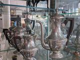 many silver vases on display in a glass case