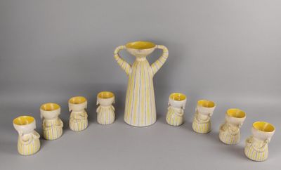 des vases et des tasses rayés de jaune et de blanc, disposés en cercle sur une surface grise