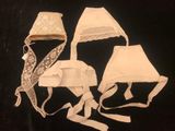 three pieces of white cloth with lace on them on a black background