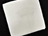 une photo d'une serviette blanche sur laquelle figure une couronne