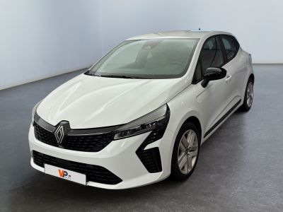 La voiture blanche est garée dans une grande pièce au sol gris.