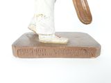 a statue of a man holding a baseball bat on top of a book