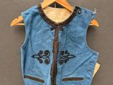 un gilet bleu accroché à un cintre au mur