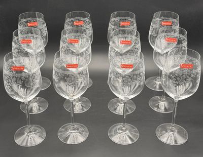 six clear wine glasses are lined up in a row on a black surface