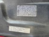 a close up of a metal plate on a red vehicle