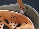 a helmet that has holes on it and a leather strap