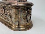 a silver box with a bird on it on a white surface