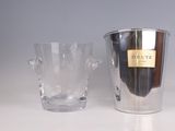 a silver ice bucket and a clear glass on a table