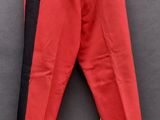 un vieux pantalon rouge accroché à un mur noir