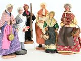 five figurines of people dressed in traditional clothing