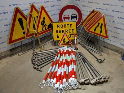 de nombreux panneaux de signalisation différents posés par terre dans une pièce