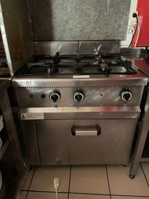 une cuisinière en acier inoxydable dans une cuisine au sol carrelé