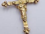 a gold cross with a statue of jesus on it