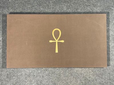 a gold ankht on a brown surface