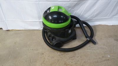 a green and black vacuum cleaner sitting on top of a floor