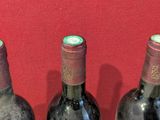 three bottles of wine sitting on a red table