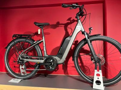 un vélo posé sur une étagère devant un mur rouge