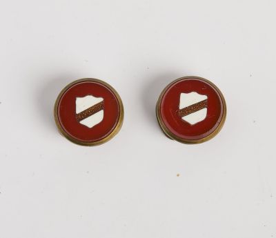 une paire de boucles d'oreilles à clous rouges et dorées ornées d'un bouclier