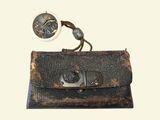 an old purse with a metal clasp and a button on it
