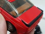 someone is holding a toy car in their hand on a table