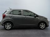 the small car is parked in the parking lot near the wall