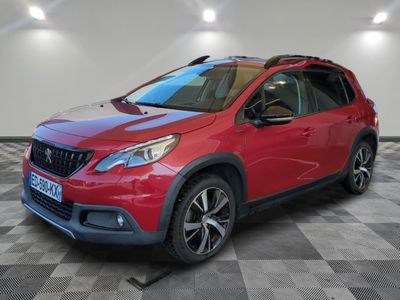 une voiture rouge garée dans un garage au sol en damier