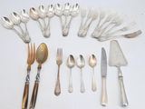 tout un service d'argenterie sur une table, comprenant un couteau, une fourchette, une cuillère et un repose-couteau
