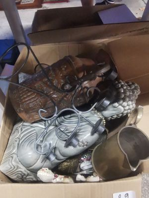 une boîte remplie d'objets hétéroclites posée sur le sol