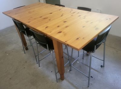 une table en bois entourée de quatre chaises dans une pièce