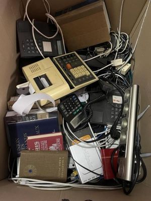 une boîte en carton remplie de matériel électronique et de livres