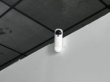 a white alarm on the ceiling of a bathroom