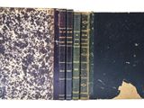 trois livres sont empilés sur une surface blanche