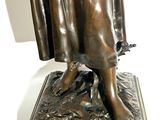 bronze statue of a woman holding a bird in her hand