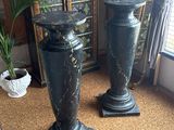 two vases that are sitting on the floor next to a cabinet