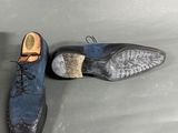pair of men ' s blue and black leather shoes on a gray surface