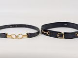 two black leather belts with gold buckles on them