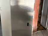 un réfrigérateur en acier inoxydable dans une cuisine dont la porte est ouverte