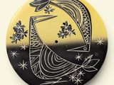 a black and yellow button with a bird on it