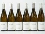 six bouteilles de vin blanc sont alignées sur une table