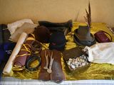 a bed with a bunch of hats and other items on it