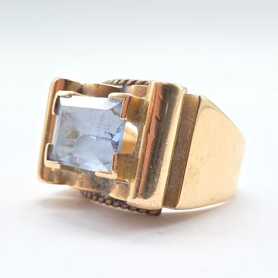 une image d'une bague en or avec une pierre bleue au centre