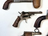 several old guns are displayed on a white surface with a white background